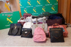 La Guardia Civil investiga a dos personas por posesión de bolsos presuntamente falsificados.