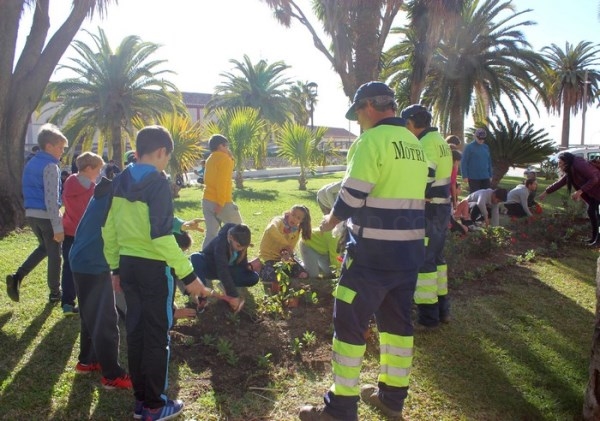 Un centenar de niños y niñas de los colegios Reina Fabiola y Luis Pastor plantan flores en los jardines del paseo de las Explanadas
