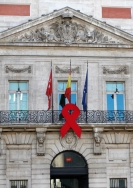 La sede de la Comunidad de Madrid luce un gran lazo rojo por el Día Mundial de la Lucha contra el Sida