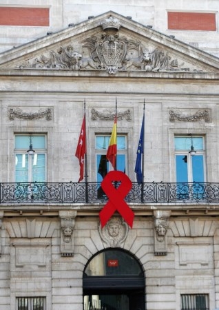 La sede de la Comunidad de Madrid luce un gran lazo rojo por el Día Mundial de la Lucha contra el Sida